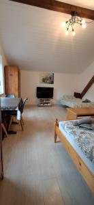 un soggiorno con 2 letti e una TV a schermo piatto di Haus Tauber a Cornaiano