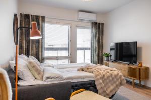 a bedroom with a large bed and a television at Unique apartment - Best location with Sauna in Rovaniemi