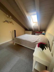a bedroom with a bed and a table with flowers on it at Duplex with terrace , pool, 2 bedrooms in Lenno +47 photos