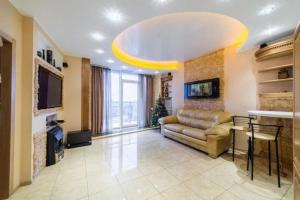 a large living room with a couch and a tv at Апартаменты Делюкс с 1 спальней in Dnipro