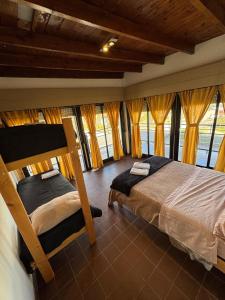 a bedroom with a bunk bed with yellow curtains at Hostel 360 Patagonia in El Bolsón +70 photos