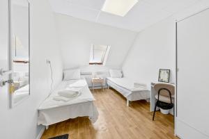 a white room with two beds and a table at Angaar - Tallinn Airport in Tallinn +21 photos