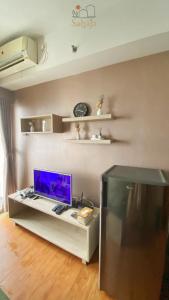 ein Wohnzimmer mit einem Schreibtisch und einem Computer darauf in der Unterkunft Margonda Residence 5 Depok by Sahaja Stay in Kemirimuka Tiga