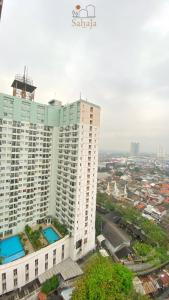 ein hohes weißes Gebäude mit einer Stadt im Hintergrund in der Unterkunft Margonda Residence 5 Depok by Sahaja Stay in Kemirimuka Tiga
