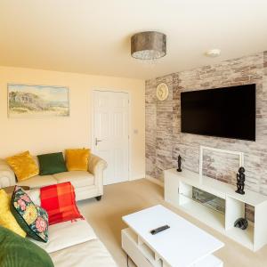 a living room with a couch and a tv at Rosengelyn Apartment in Sheffield