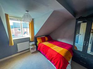 a bedroom with a bed with a red and yellow blanket at Rosengelyn Apartment in Sheffield