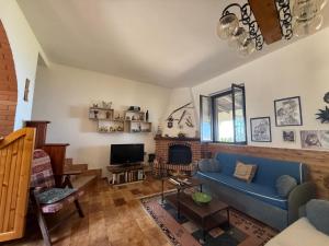 a living room with a blue couch and a fireplace at Villa Shanti a Romitello - "RUSTIC" & "ETHNIC" apartments in Borgetto
