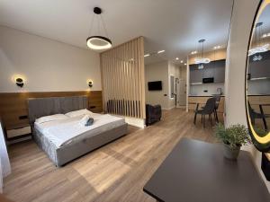 a bedroom with a bed and a living room at Уютная в центре города in Zhezdi