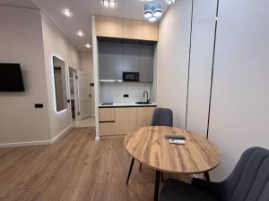 a room with a table and chairs and a kitchen at Уютная в центре города in Zhezdi