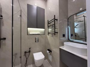 a bathroom with a toilet and a sink and a mirror at Уютная в центре города in Zhezdi +8 photos