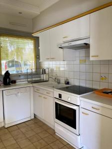 a kitchen with white cabinets and a stove top oven at Villa Pratel Vihan - plage in Sarzeau +12 photos