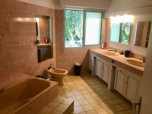 a bathroom with a tub and two sinks and a toilet at Villa Pratel Vihan - plage in Sarzeau