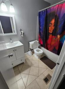 a bathroom with a painting of a woman on the shower curtain at Cozy place! in Baltimore