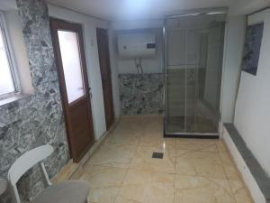 a bathroom with a shower and a glass door at Cozy Basement in Prizren