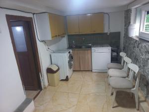 a small kitchen with chairs and a white refrigerator at Cozy Basement in Prizren