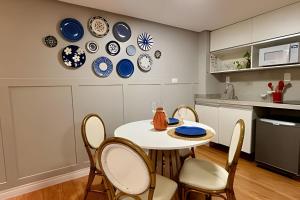 a kitchen with a table and chairs and plates on the wall at Flat à beira mar Imperial Flat - MyFlats Hospedagens in Tambaú