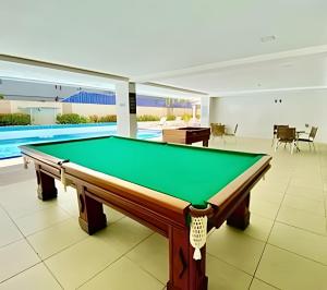 a pool table in a house with a swimming pool at Flat à beira mar Imperial Flat - MyFlats Hospedagens in Tambaú