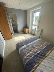 a bedroom with a bed and a large window at Appartement T2 Centre Pont Réan in Guichen