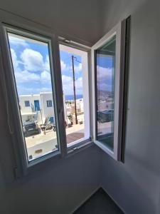 two windows in a room with a view of a city at Gazia Sea View House - Mykonos Town in Mikonos
