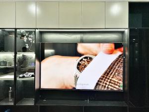 a television with a picture of a person with a watch at Vinhome D'capitale - Tran Duy Hung in Hanoi