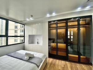 une chambre avec un lit et une grande fenêtre dans l'établissement Vinhome D'capitale - Tran Duy Hung, à Hanoï