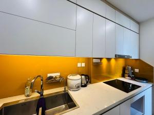 a kitchen with white cabinets and a sink at Vinhome D'capitale - Tran Duy Hung in Hanoi