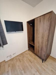 リンツにあるCity-Flat Linz Self-Check-Inの薄型テレビ付きの客室内の大きな木製キャビネット