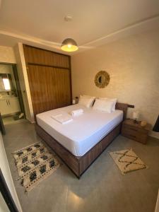 una camera da letto con un letto bianco e uno specchio di Beldi Chic à Sidi Ifni Confort Premium a Sidi Ifni