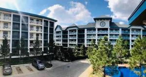 a large building with a clock tower on top of it at Cozyluxe at Pine Suites Tagaytay in Kaybagal