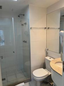 a bathroom with a toilet and a glass shower at Maravilhoso Flat Vision in Brasilia +9 photos