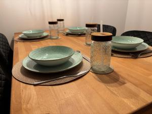 a wooden table with plates and bowls on it at Ferienwohnung Naturkraft mit Tiefgaragenstellplatz und Balkon in Oberhof +6 photos