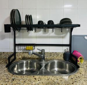 a kitchen sink with plates and pans on a shelf at AShostEcuador, Quito, rooms & suits, Quito cerca parque La Carolina in Quito