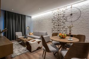 a living room with a couch and a table and chairs at Zlatibor Lux Spa Apartments in Zlatibor