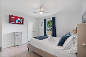 Un dormitorio con una cama con almohadas azules y una ventana. en Play & Stay - Freshly Updated, Workspace & Games, en Clarksville