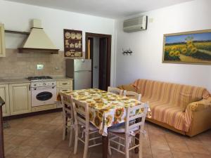 a kitchen and living room with a table and a couch at Il Girasole in Venturina Terme