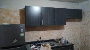 eine Küche mit schwarzen Schränken und einer Spüle in der Unterkunft Casa mabe in Hermosillo