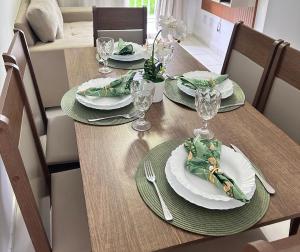 une table en bois avec des assiettes et des verres dans l'établissement Arara Paraense, à Ananindeua