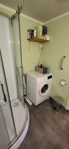 a bathroom with a shower and a washing machine at Marias Guesthouse in Tromsø