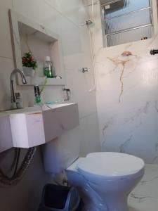 a bathroom with a toilet and a sink at Apartamento mobiliado in Itabuna