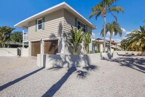a house with palm trees in front of it at Surf Riders home in Holmes Beach