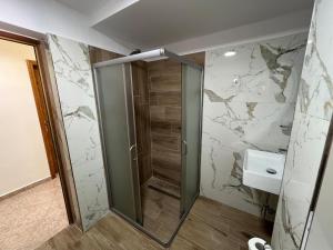 a bathroom with a glass shower and a sink at Camaj Nest in Gjirokastër +2 photos
