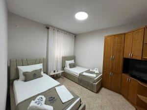 a hotel room with two beds and a television at Camaj Nest in Gjirokastër