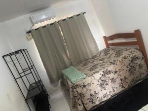 a small bedroom with a bed and a window at Casa Grande, 3 quartos in Juína