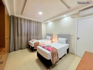 Una habitación de hotel con dos camas y una ventana. en Apt 01 Alto Padrão 3 quartos ao lado do Paraguai, en Foz do Iguaçu