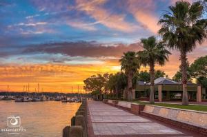 ein Sonnenuntergang über einem Yachthafen mit Palmen und einem Gebäude in der Unterkunft Pinky's Palace Cozy Bungalow in Port Royal