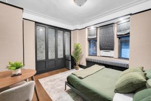 a bedroom with a bed and a table and windows at Unbeatable Location The Heart of NYC 1 BDR W GYM in New York +16 photos
