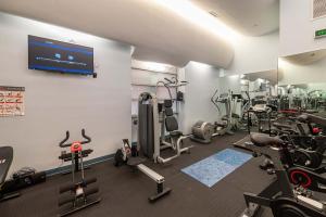 a gym with several tread machines and a flat screen tv at Unbeatable Location The Heart of NYC 1 BDR W GYM in New York