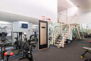 a gym with tread machines and a spiral staircase at Unbeatable Location The Heart of NYC 1 BDR W GYM in New York