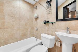 a bathroom with a toilet and a sink and a bath tub at Unbeatable Location The Heart of NYC 1 BDR W GYM in New York