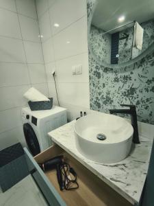 a bathroom with a white sink and a mirror at Aura Apartamenty in Brzeg +25 photos